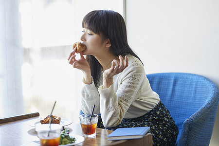 吃着面包的年轻女子图片