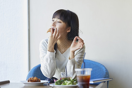 年轻女子在咖啡馆吃下午茶图片