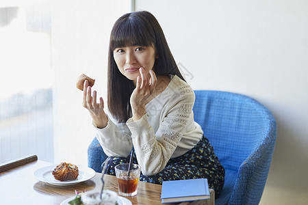 年轻女子在咖啡馆吃下午茶图片