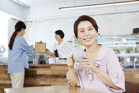 咖啡厅喝咖啡的中年女性图片