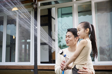 在庭院生活玩耍的父女高清图片