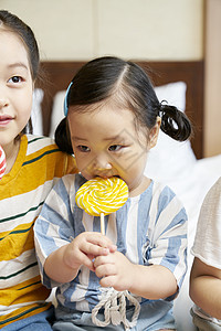 卧室里生活的孩子吃着棒棒糖图片