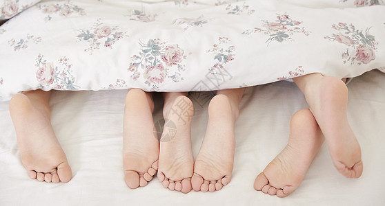 三人小朋友趴在床上脚部特写高清图片