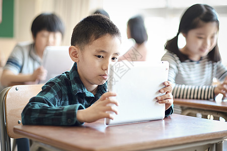 小学生使用平板电脑学习讨论图片