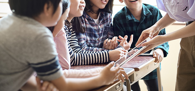 小学生在老师的指导下学习平板电脑使用知识图片