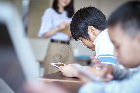 同学背影老师在教学生如何使用数码产品学习背景