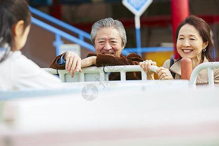 在游乐园里的老年夫妇带着孙女游玩图片