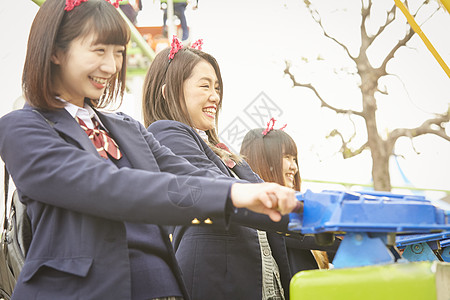 日本女孩高中女孩在游乐园里玩背景