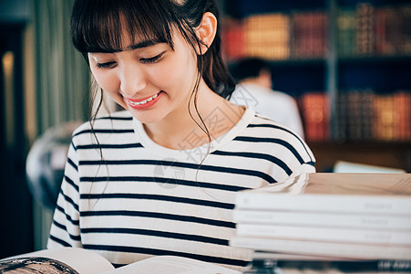 学生女士杂志读一本书的妇女在图书馆里图片