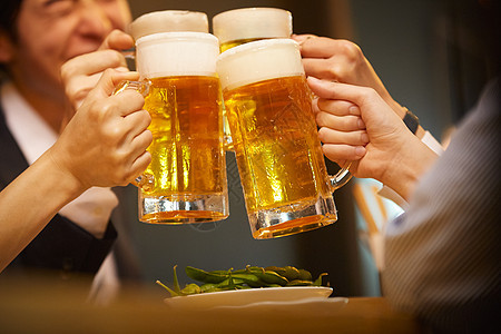年轻白领聚会喝啤酒碰杯背景图片