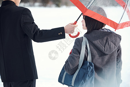 户外雪地男子给女生打伞图片