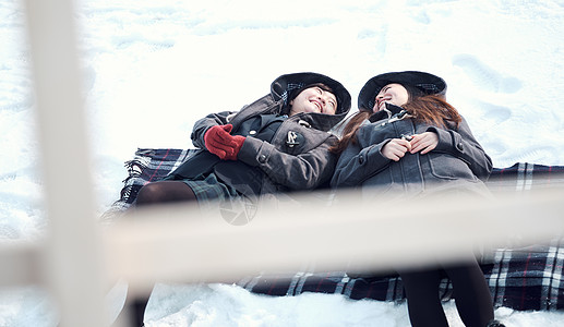 干杯同学户外高中女孩在躺在雪地里享受背景