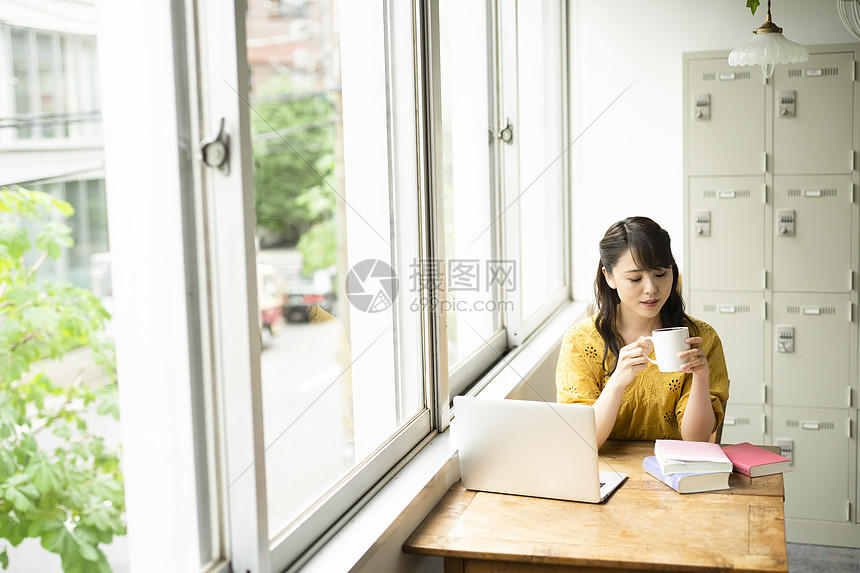 在咖啡店喝咖啡办公的女性图片