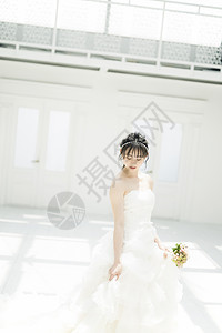 室内穿着婚纱拿着手捧花的新娘图片