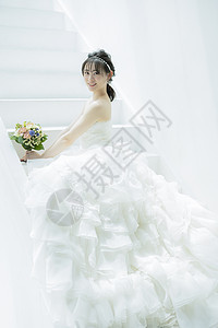 坐在台阶上拿着手捧花的新娘图片