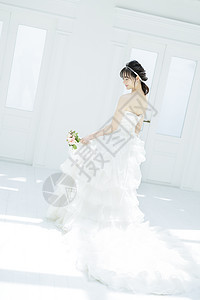 穿着纯白的婚纱拿着手捧花的美女背影图片