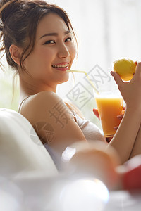 喝果汁微笑的年轻女子图片