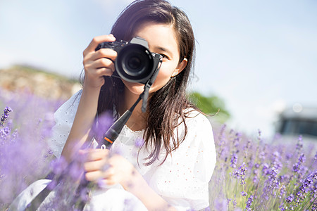 肖像户外摄影机与花田和照相机的妇女画象图片