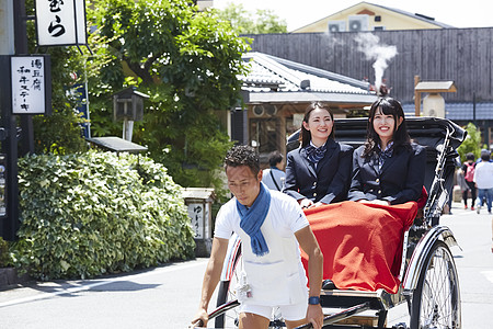 学校大道两个高中女孩乘坐人力车游玩背景