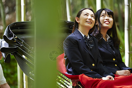 两名高中女孩开心的乘坐人力车旅游图片