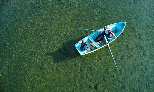 高角男人们划桨家庭旅行湖船图片