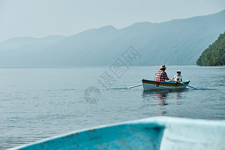 壮年划桨由外向内优良家庭旅行湖船图片