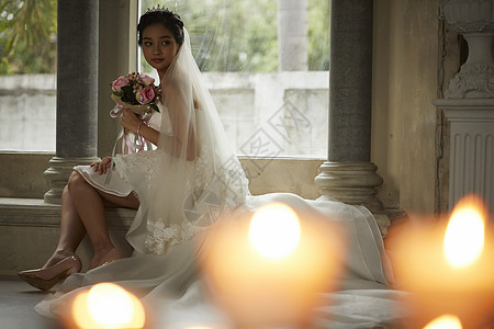 室内坐在台阶上拿着手捧花的新娘图片
