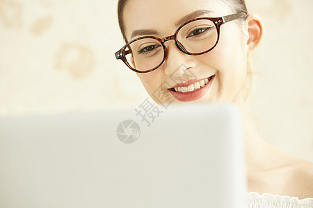 戴着眼镜看笔记本电脑的年轻女子图片