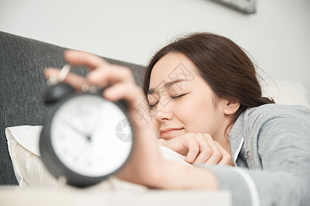 起床闹钟睡觉睡衣晚立管一个醒着的女人在床上背景