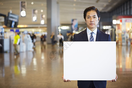 商务男士机场接机手拿展示牌图片