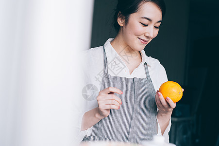 年轻女人在家拿着水果图片