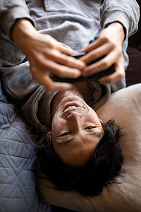 躺着玩手机开心的男性图片
