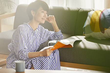 居家拿着杂志的成年女子图片