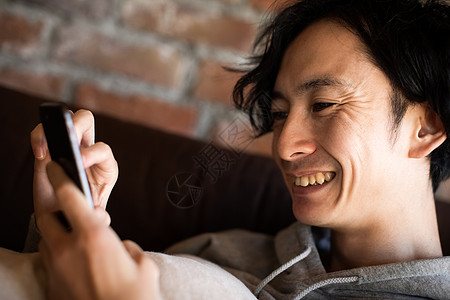 看着手机开心大笑的成年男子图片