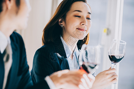 三十几岁窗口一起吃饭拿着酒杯的上司妇女在餐馆图片