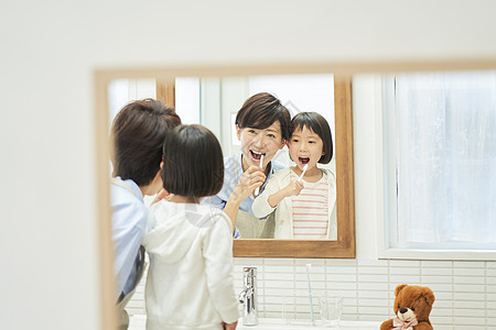 母女对着镜子刷牙齿轮高清图片素材