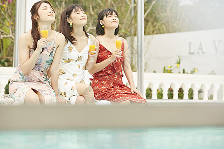度假泳池的女人聚会喝果汁图片