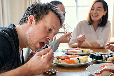 寿司盘享受美食的外国人背景