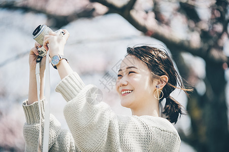 微笑丰胸乐趣樱花拍照片的春天妇女图片