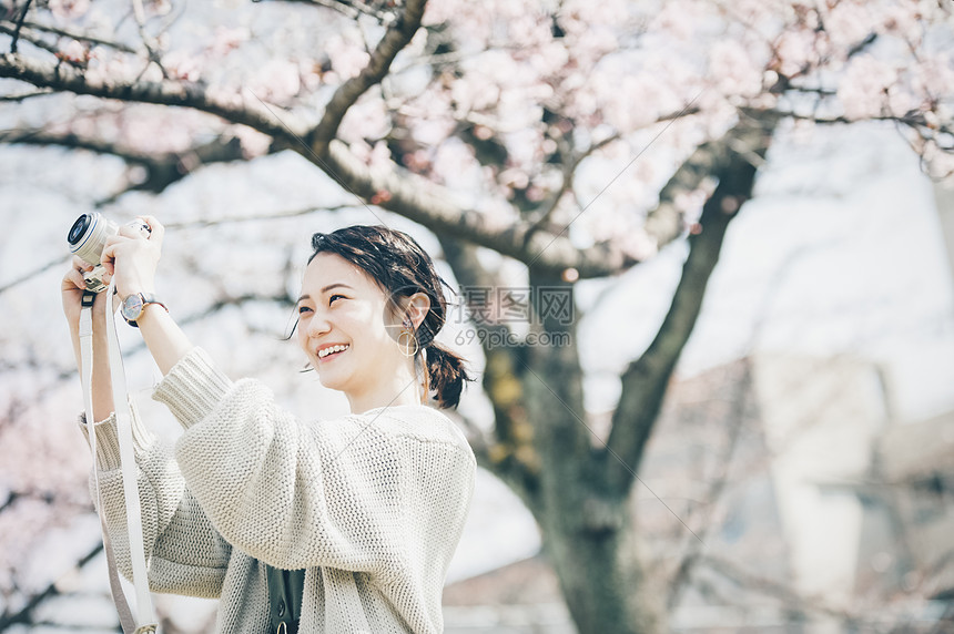 30多岁享受单人樱花拍照片的春天妇女图片