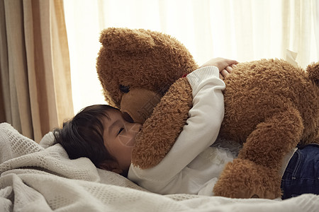 室内幼儿四岁睡觉与一头大熊的女孩在床上图片