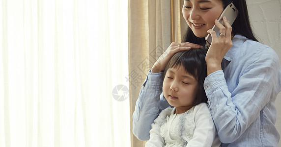 母亲打电话被母亲抱在地板上睡觉的女孩背景