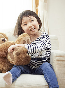 使用与在长沙发的一头大熊的饱满的女孩图片