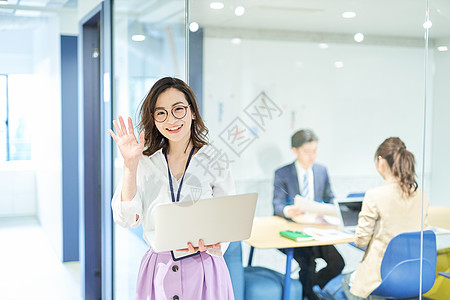 商务办公楼会议室外拿电脑的职场白领女性背景