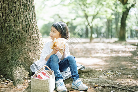 公园郊游吃三明治的小女孩图片