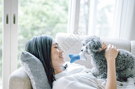 房间抱着可爱宠物狗的女人图片