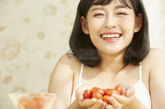 捧着小番茄微笑的青年女子图片