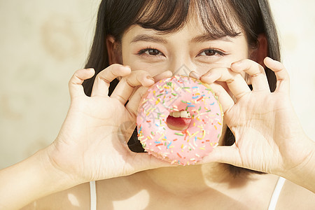 拿着甜甜圈的年轻女子图片