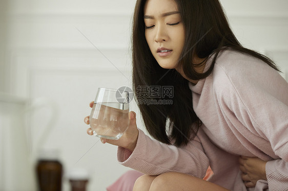 身体虚弱的女人端水杯吃药图片