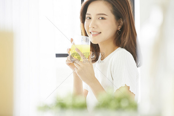 窗边喝饮料的年轻女人图片